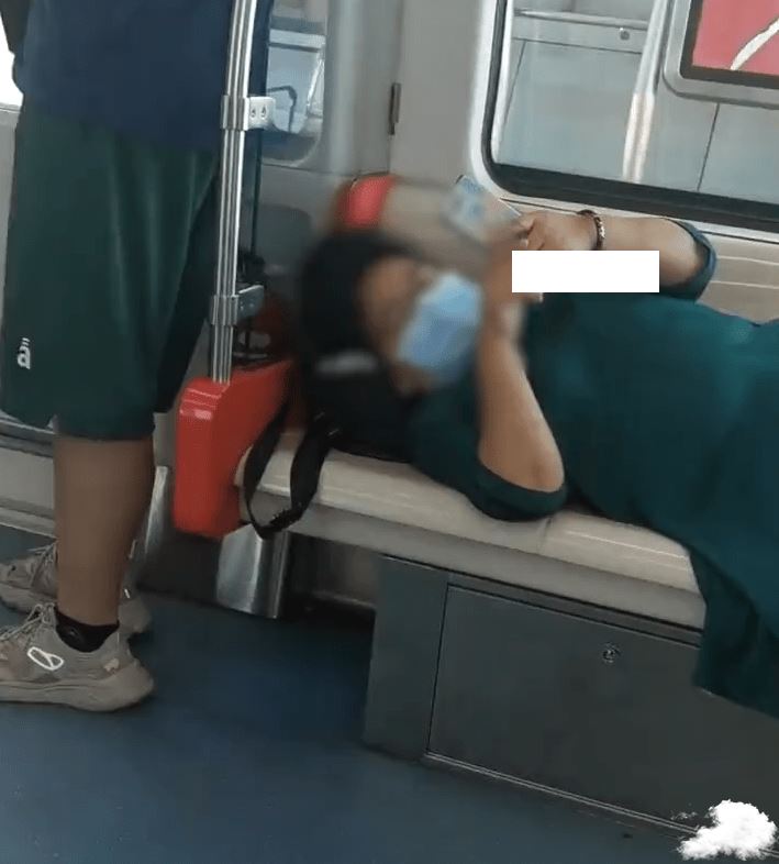 大妈横躺霸占地铁座位玩手机 一旁乘客无奈站着 大妈地铁抢座位